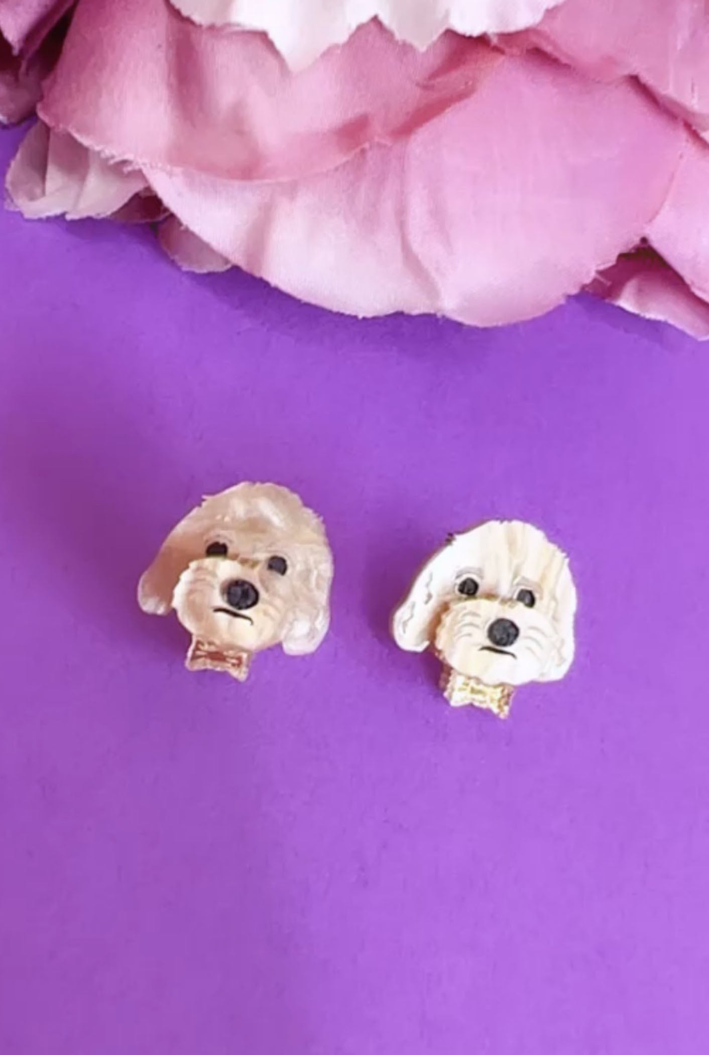 Acrylic dog earrings on purple background